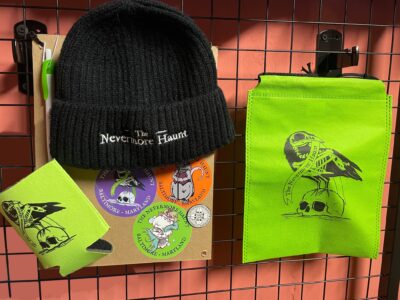 Nevermore Swag Bag - $25 - featuring a Nevermore beanie, sticker pack, enamel pin, pen and drink koozie inside of a branded draw string bag. Swag bags are included as part of the VIP package